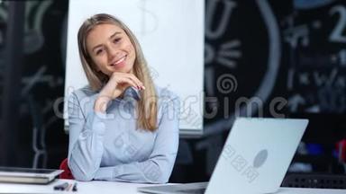 友好微笑的年轻女商人看着相机在现代办公室享受美好时光的肖像